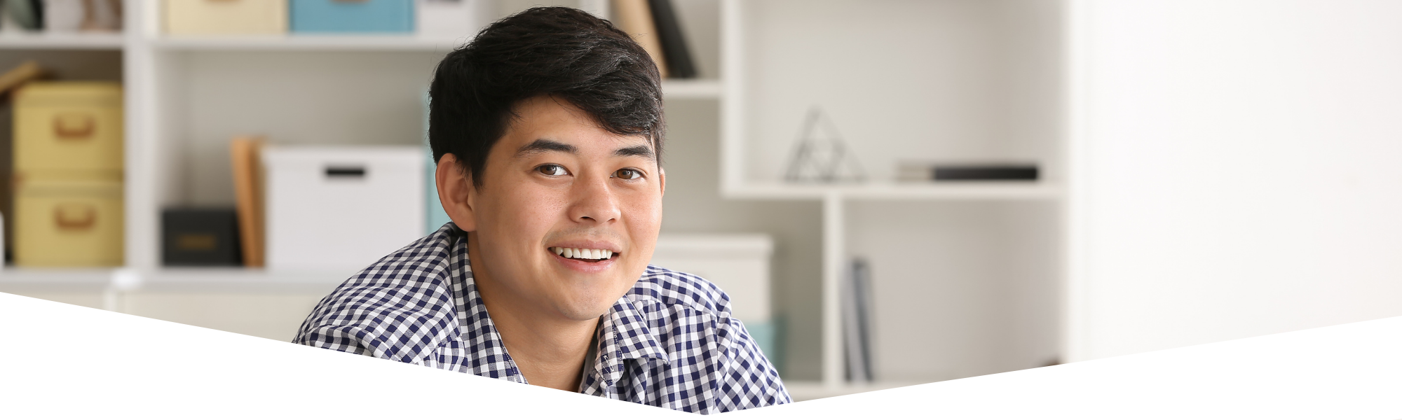 young man smiling in classroom setting 